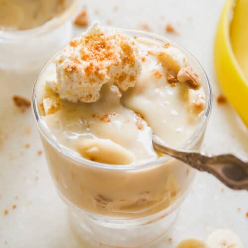 Small glass of dairy free banana pudding with a spoon resting inside.