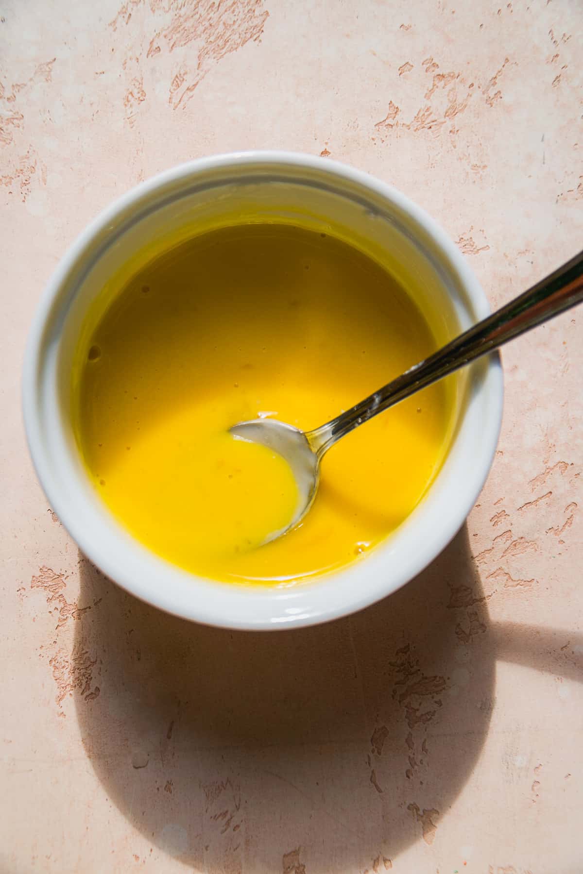 Overhead view of a bowl with whisked egg yolks.