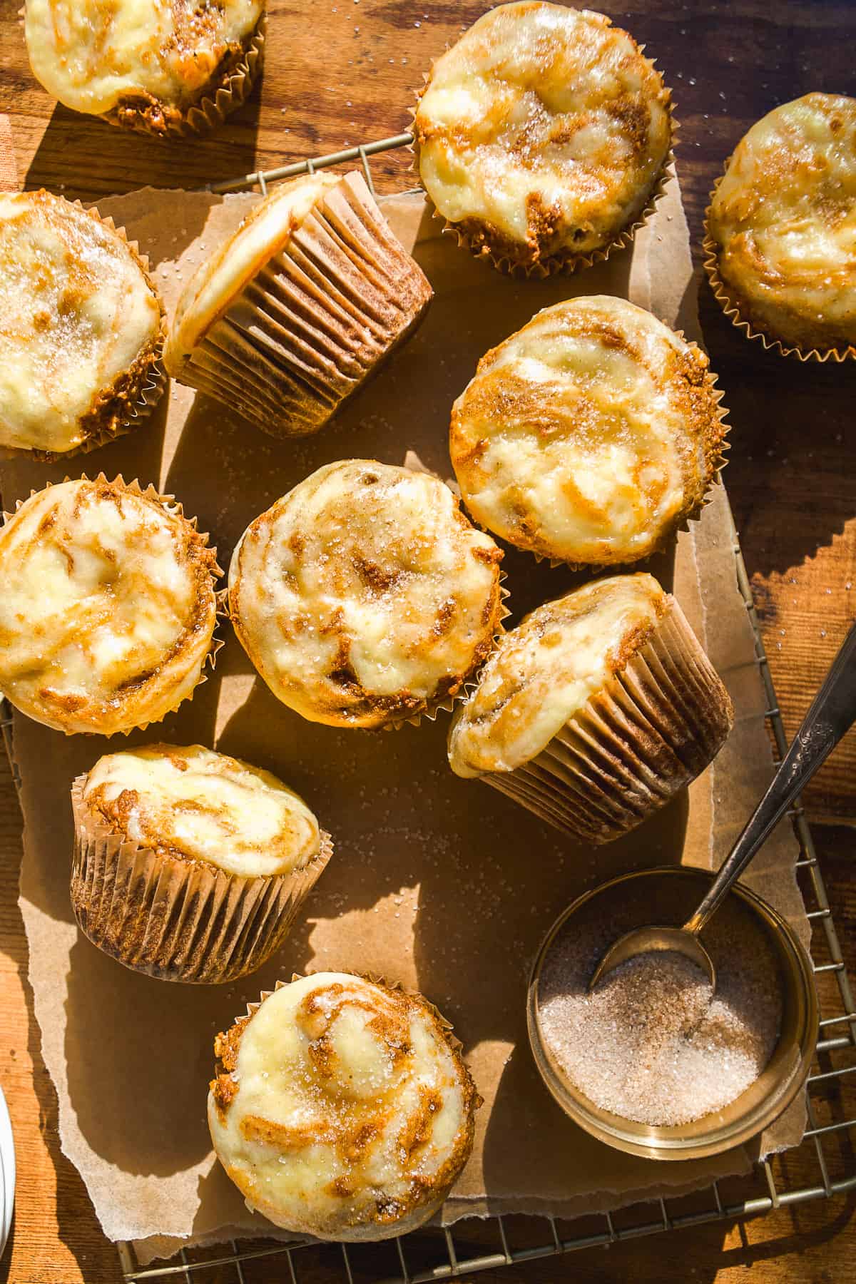 Almond flour pumpkin muffins with cream cheese swirl scattered on wire rack.