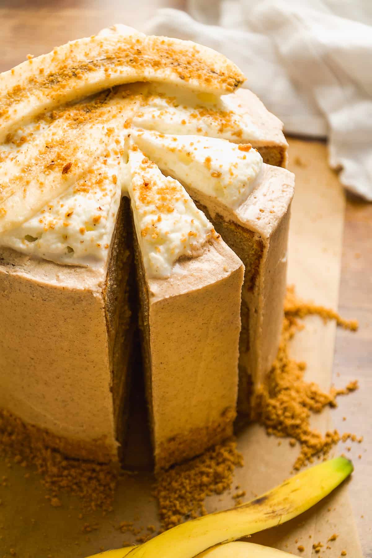 Gluten free banana cake with whipped cream on top and two pieces cut out.