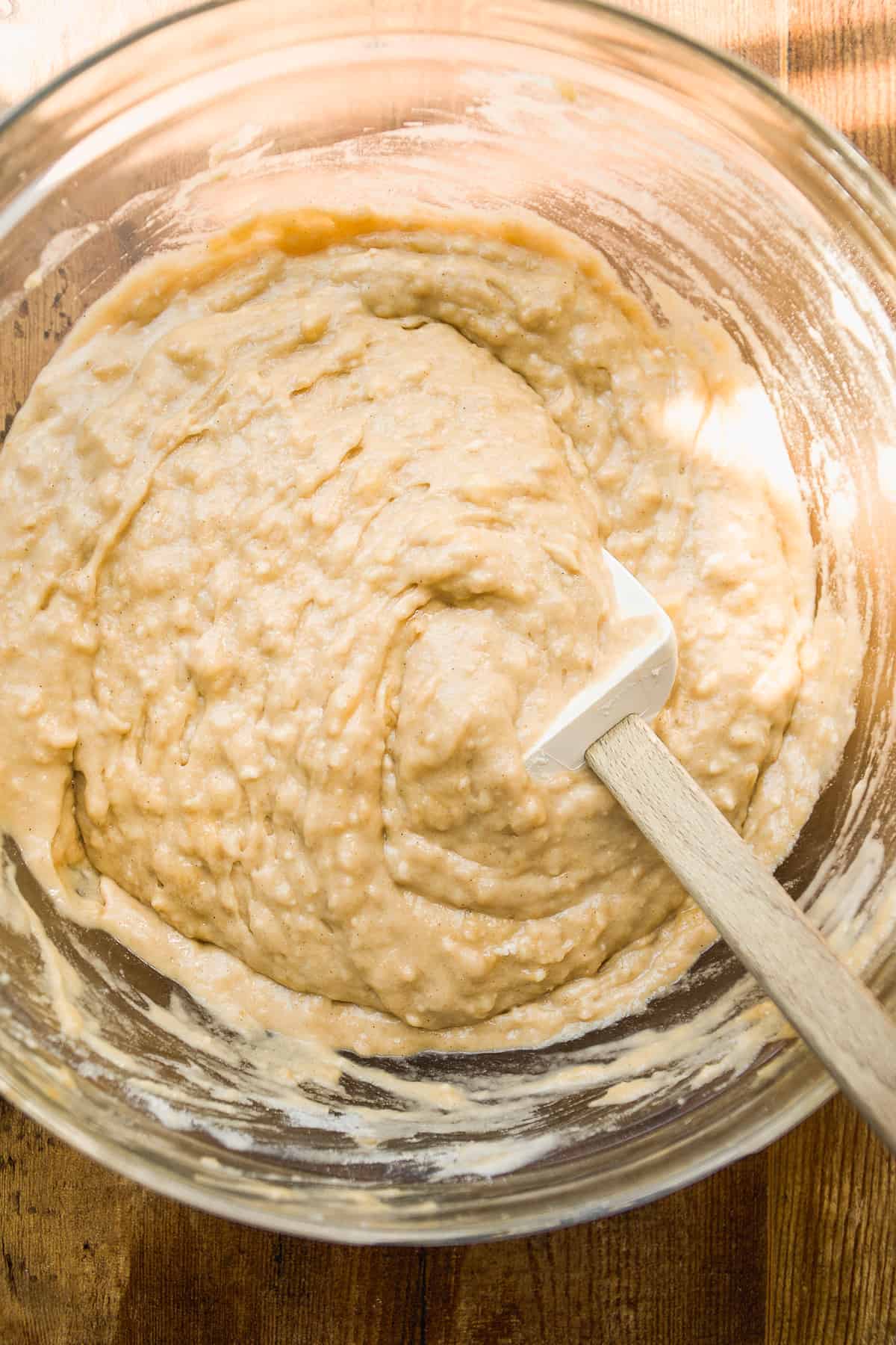 Overhead view of a glass bowl with gluten free banana cake batter.