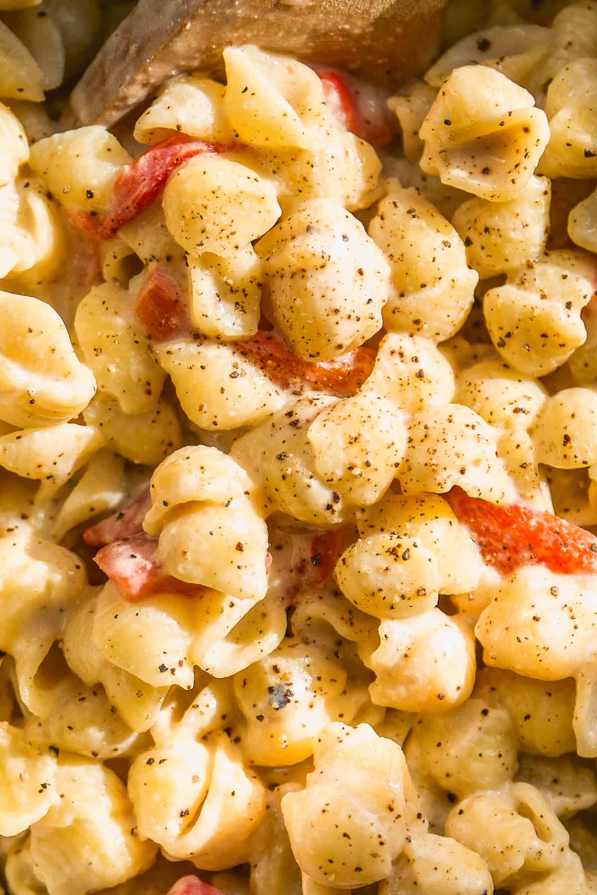 Close up image of creamy tahini pasta with red peppers.
