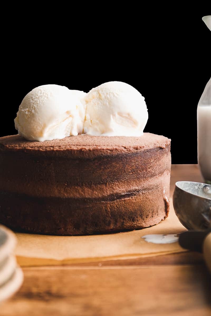 Layered brownie cake with ice cream on top.