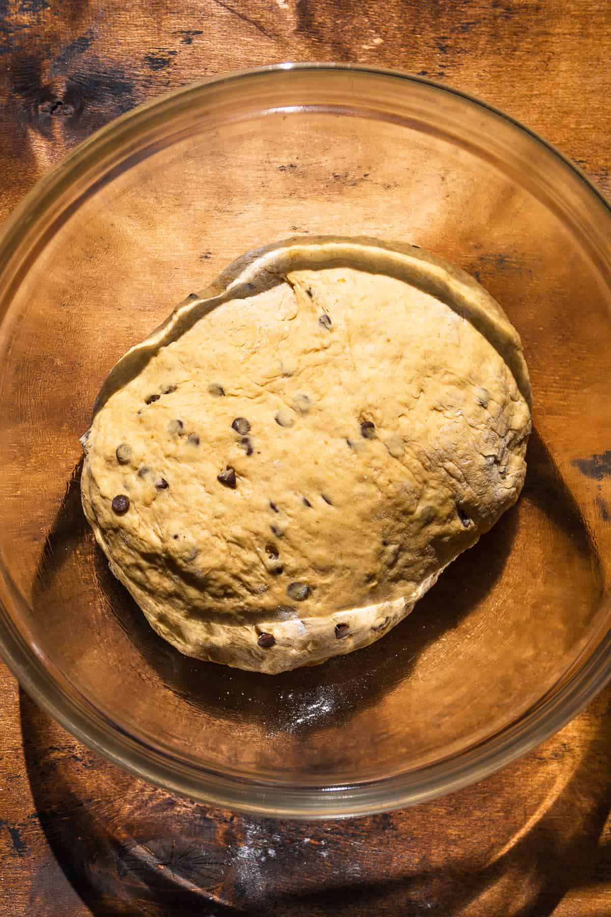 Pumpkin soft pretzel dough in a glass bowl about to rise.