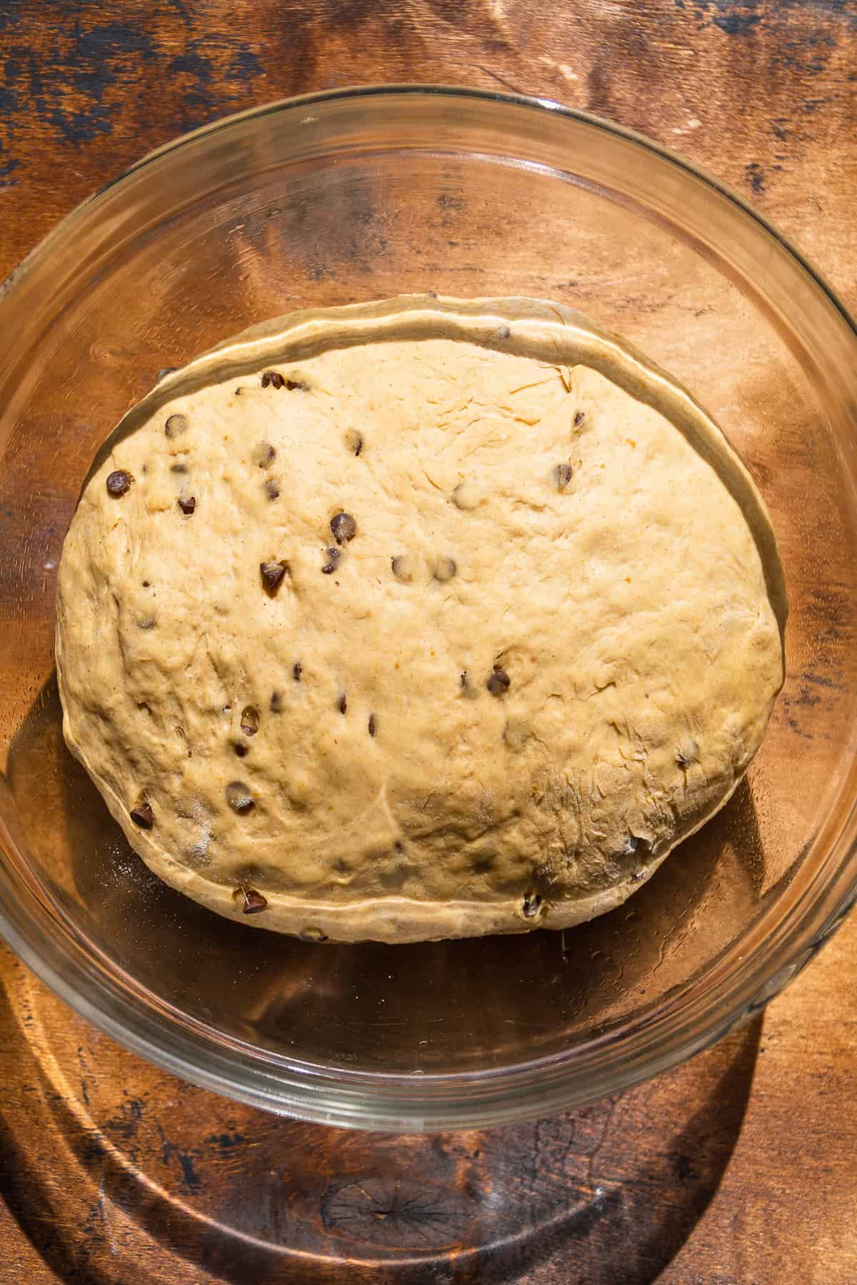 Pumpkin soft pretzel dough in a glass bowl after it has risen.