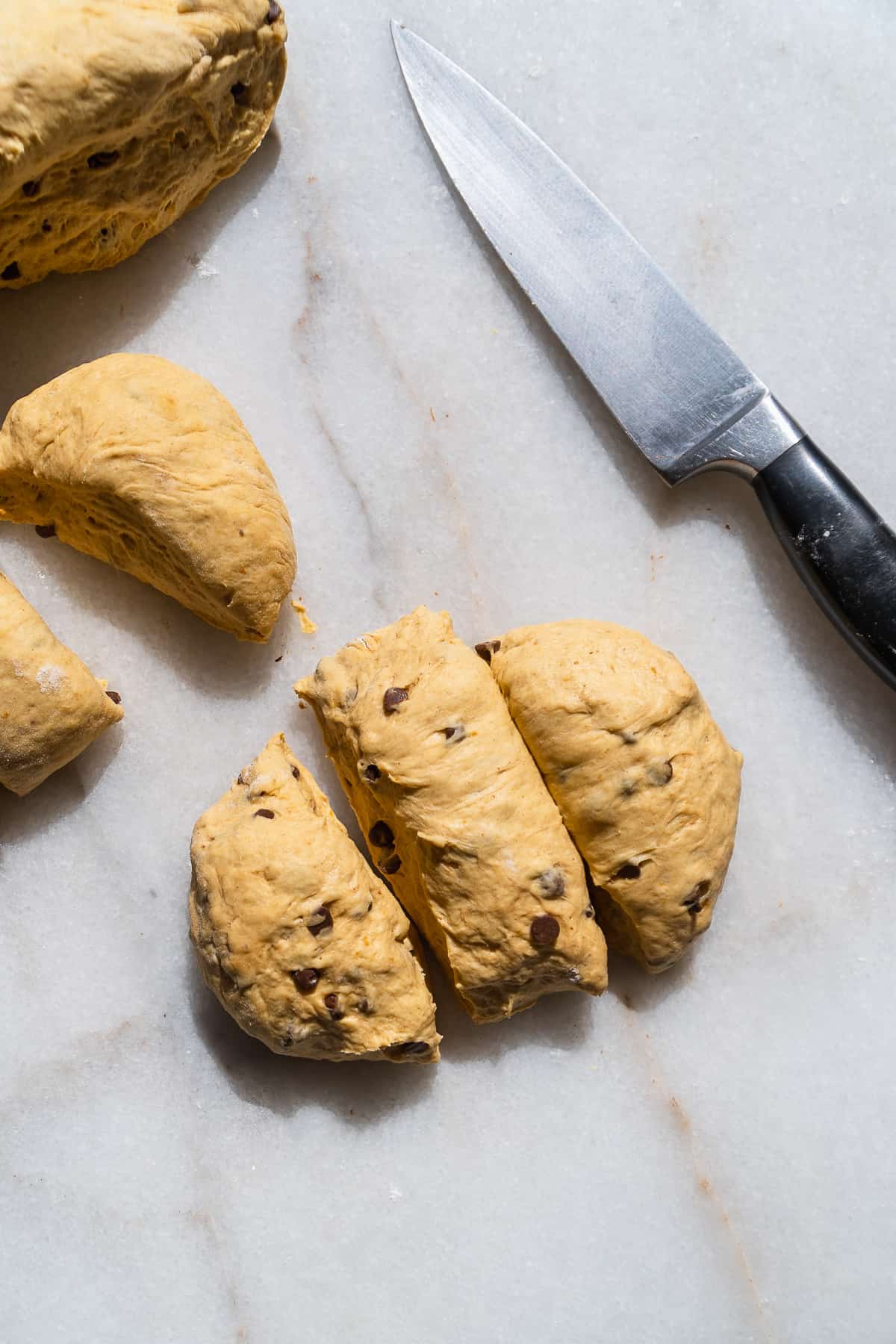 Pumpkin soft pretzel dough cut into pieces.