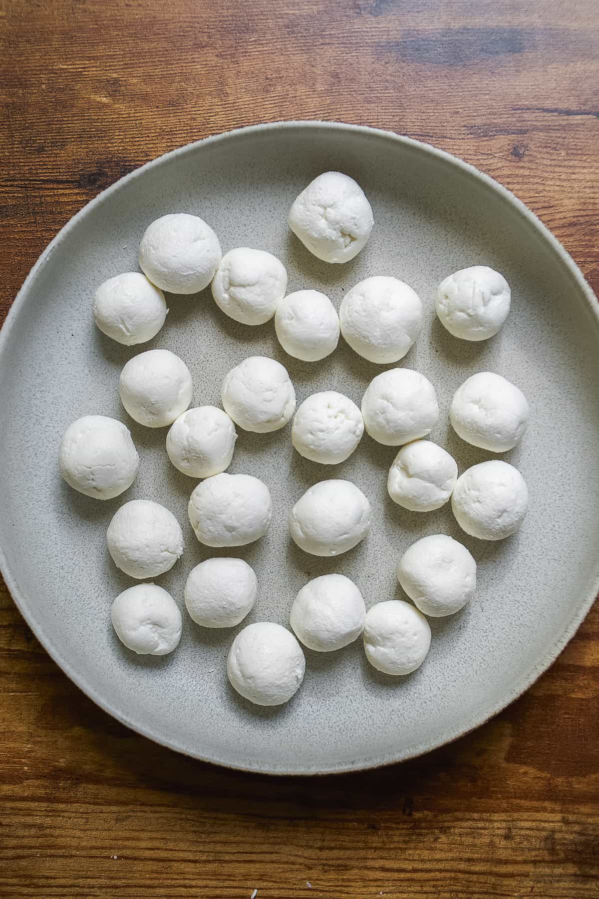 Goat cheese balls on a blue plate.