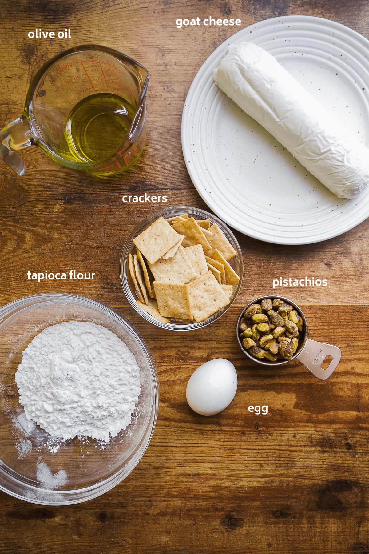 Fried goat cheese ball ingredients on a wooden surface.