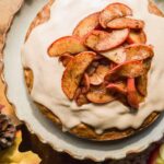 Overhead view of an apple cake with cinnamon apples and icing.