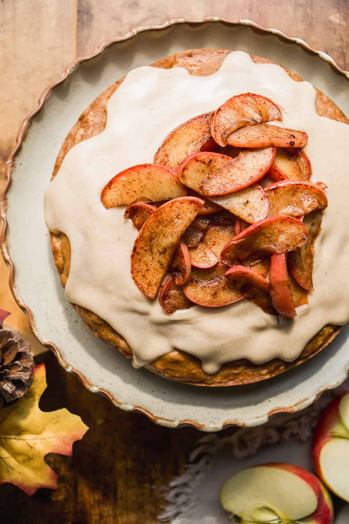 Overhead view of an apple cake with cinnamon apples and icing.