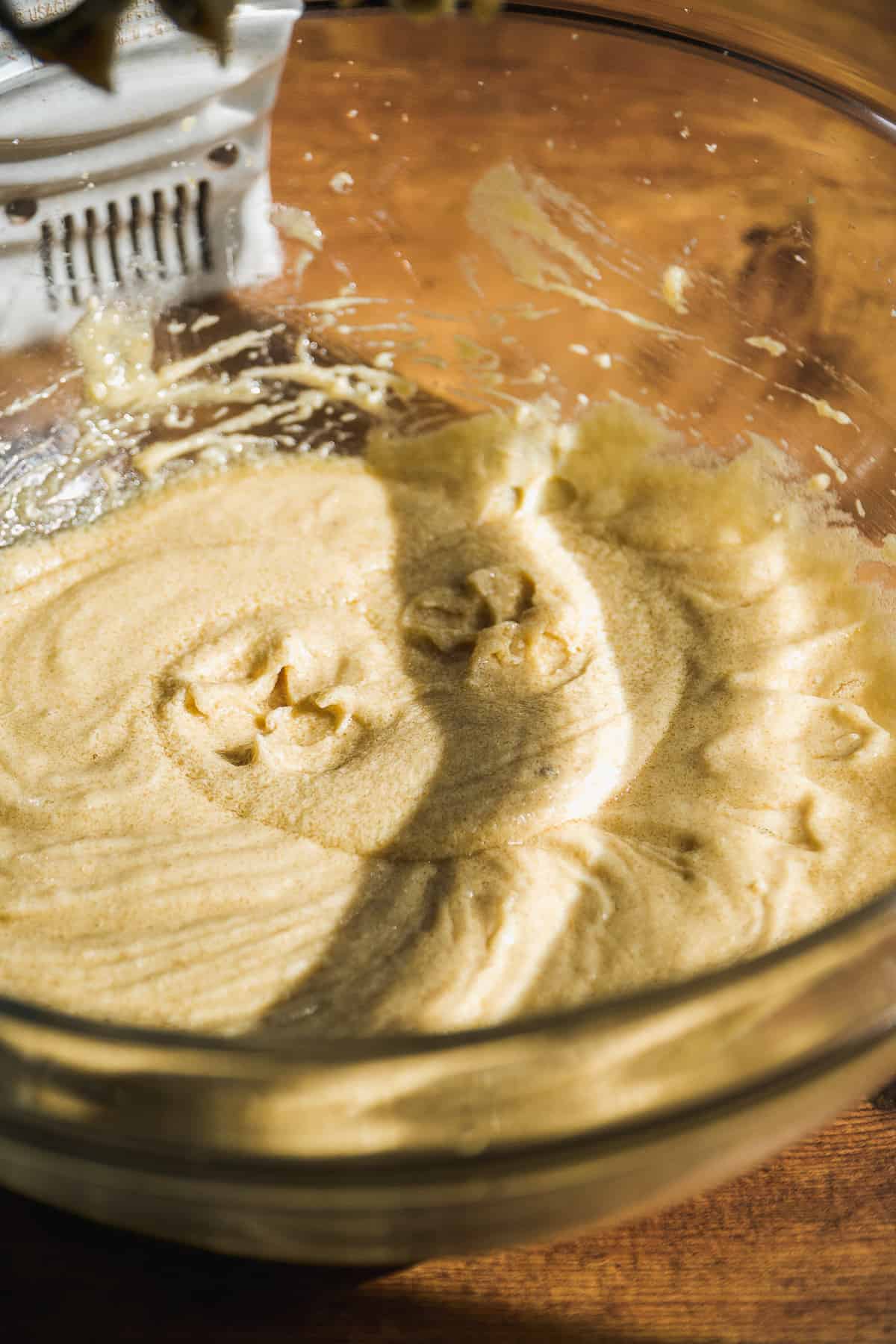 Wet ingredients being mixed in a large glass bowl.