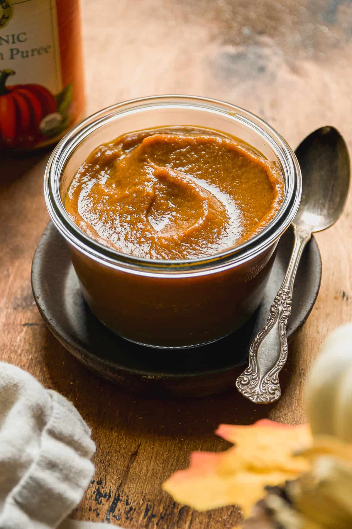 Pumpkin butter in a jar with a spoon.