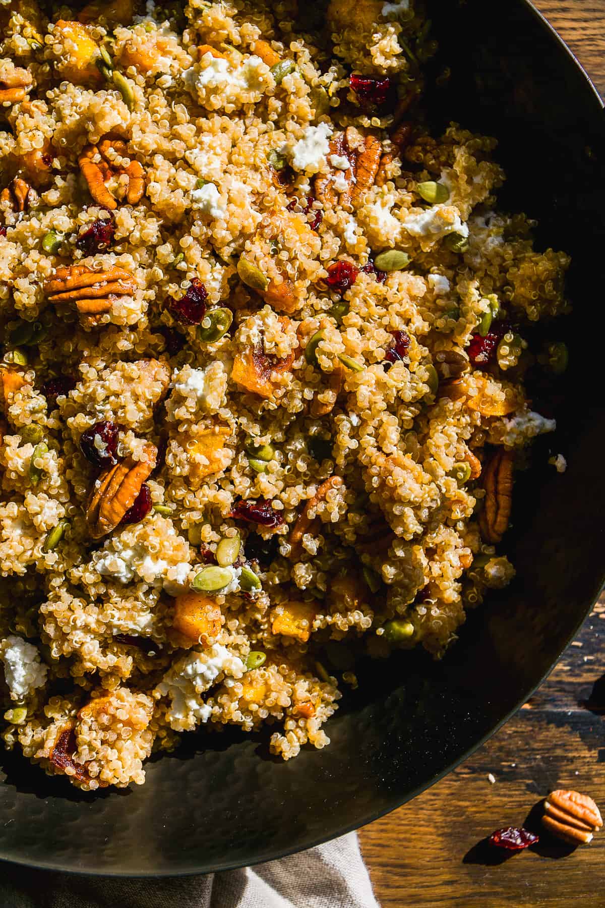 Black bowl with pumpkin quinoa salad.