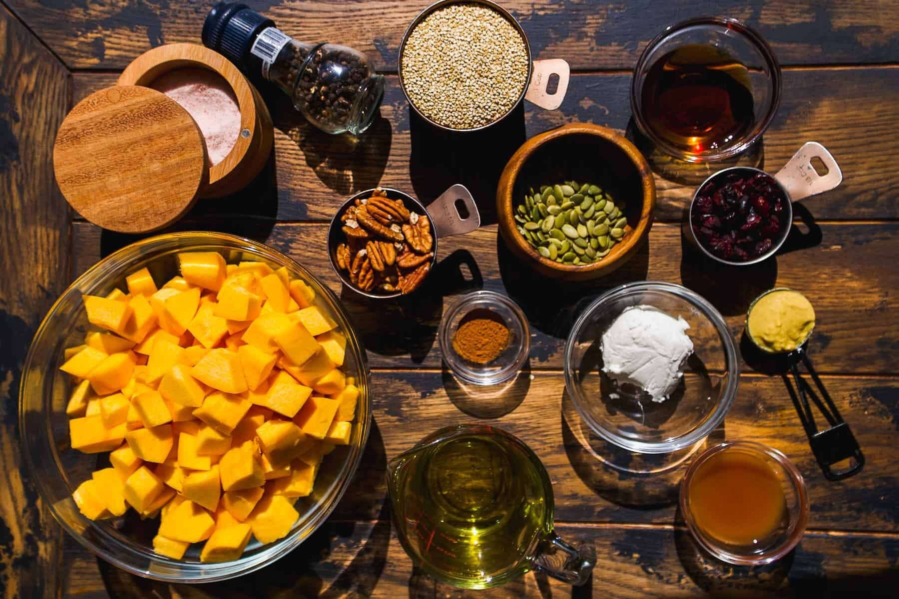Pumpkin quinoa salad ingredients on a wooden surface.