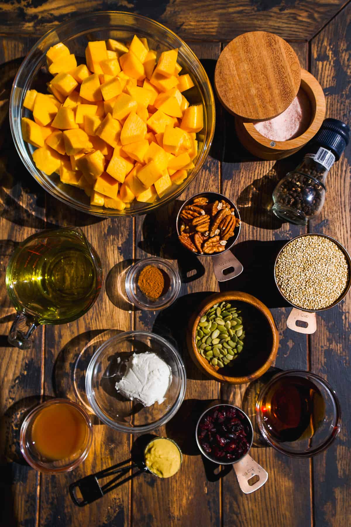 Pumpkin quinoa salad ingredients on a wooden surface.