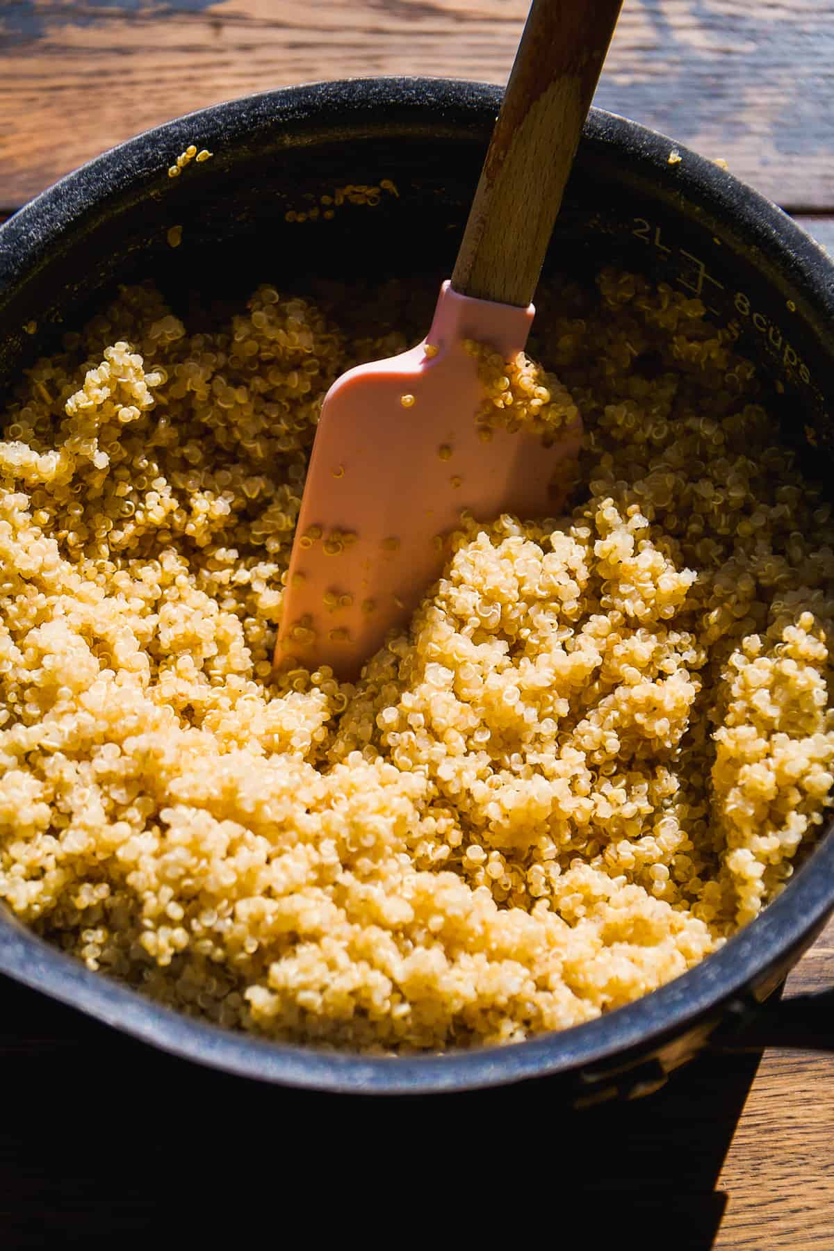 Pot of cooked quinoa with a spatula inside.