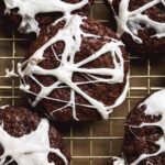 Chocolate spider web cookies on a wire rack.