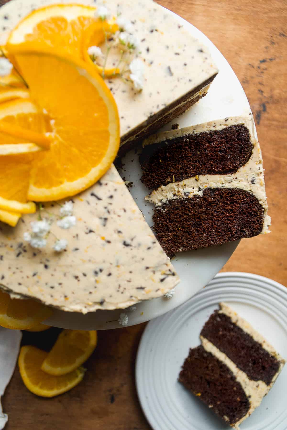 Chocolate orange cake on a cake stand with a slice laying down.