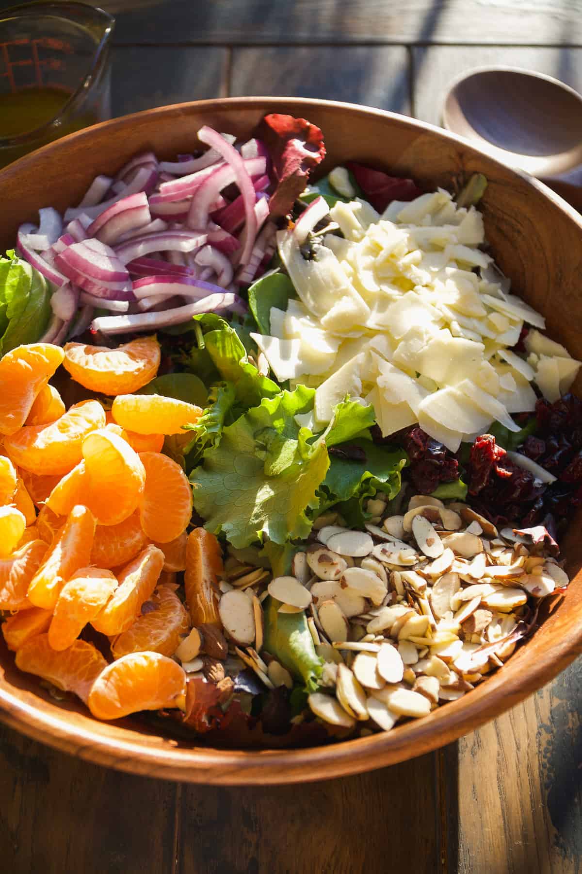 Mandarin orange salad ingredients in a wooden bowl.