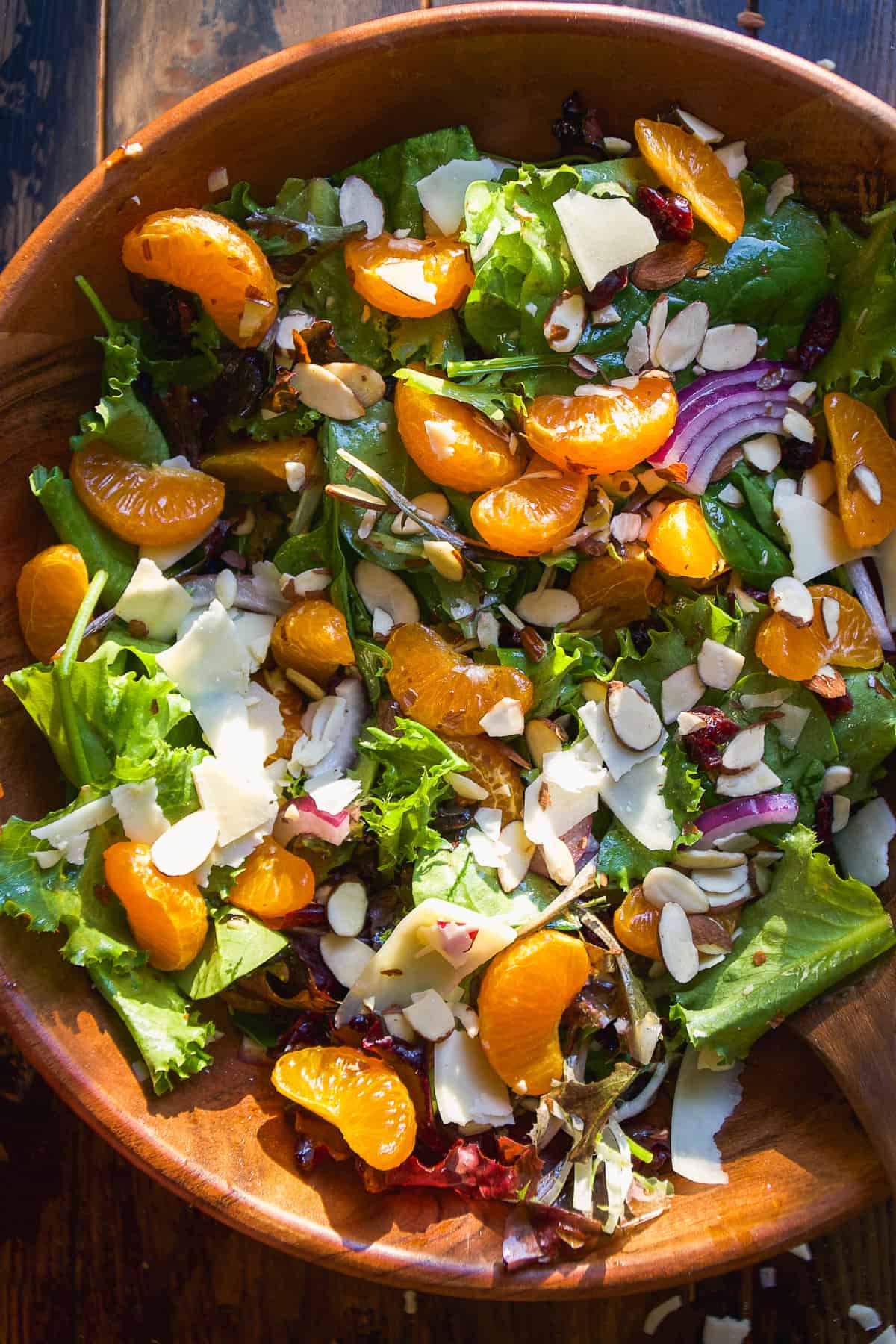 Mandarin orange salad mixed together in a bowl on a wooden surface.