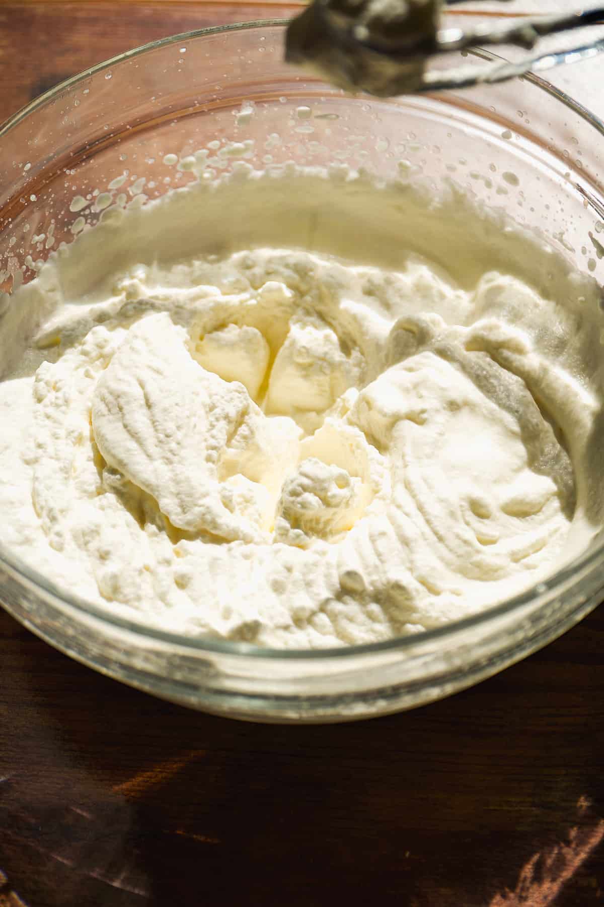 Heavy cream mixed in a bowl until thick.