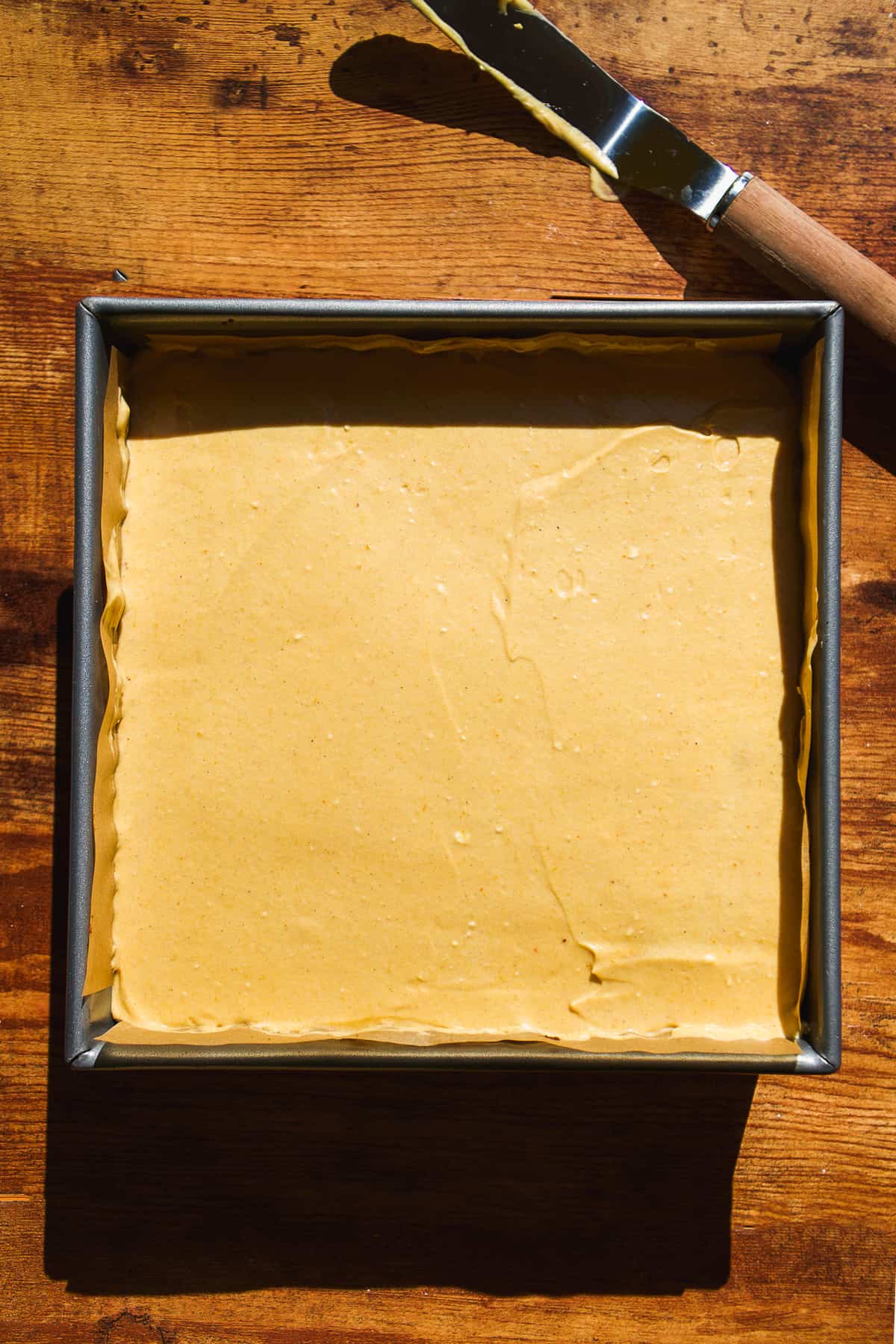 Pumpkin cheesecake in a square baking dish.