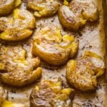 Crispy smashed potatoes on a baking sheet.