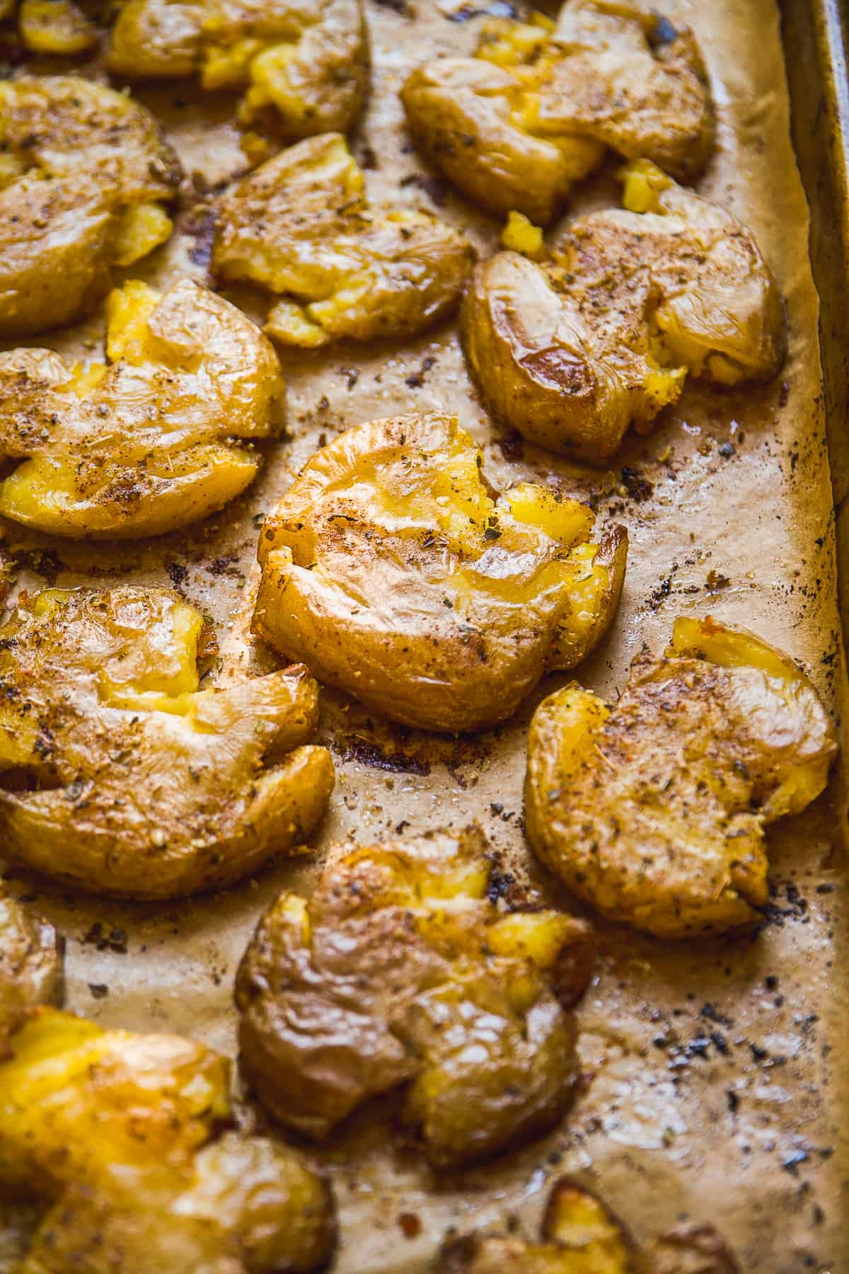 Crispy smashed potatoes on a baking sheet.