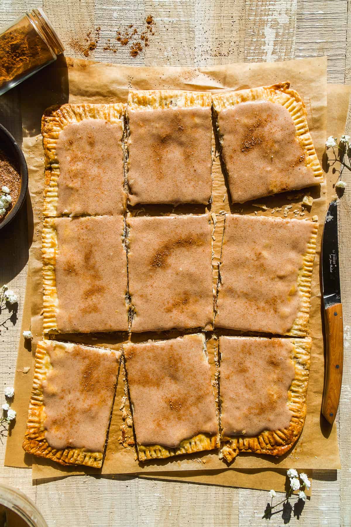 Overhead view of a giant snickerdoodle pop tart cut into pieces.