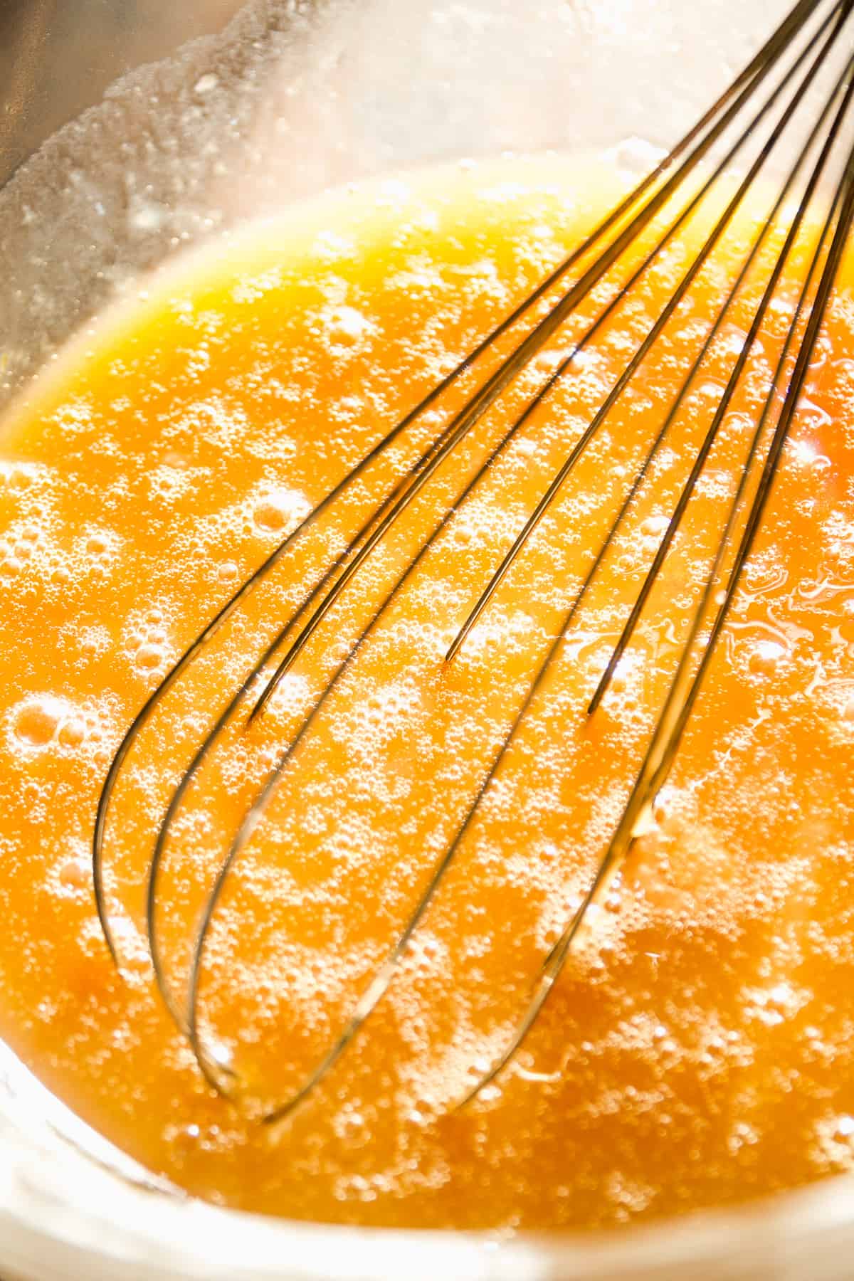 Maple caramel being mixed in a glass bowl.