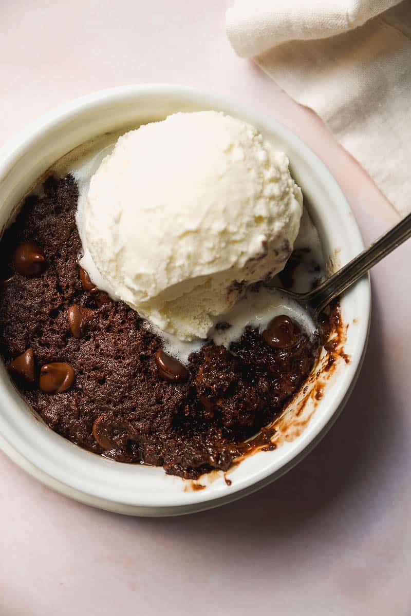 Overhead view of a vegan mug brownie with ice cream on top.