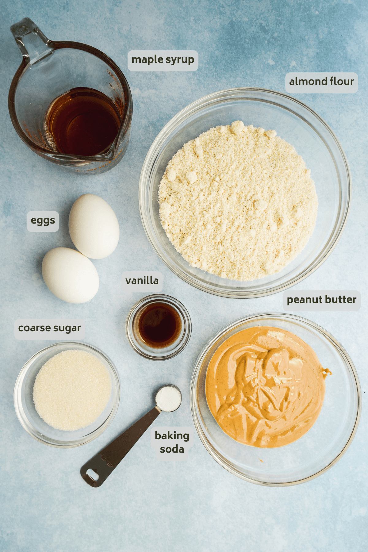 Peanut butter almond flour cookie ingredients on a blue surface.