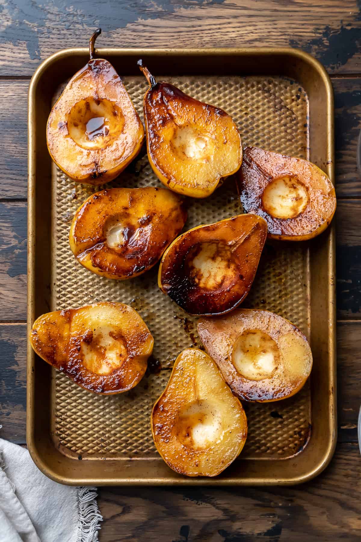 Caramelized pear halves on a baking sheet.