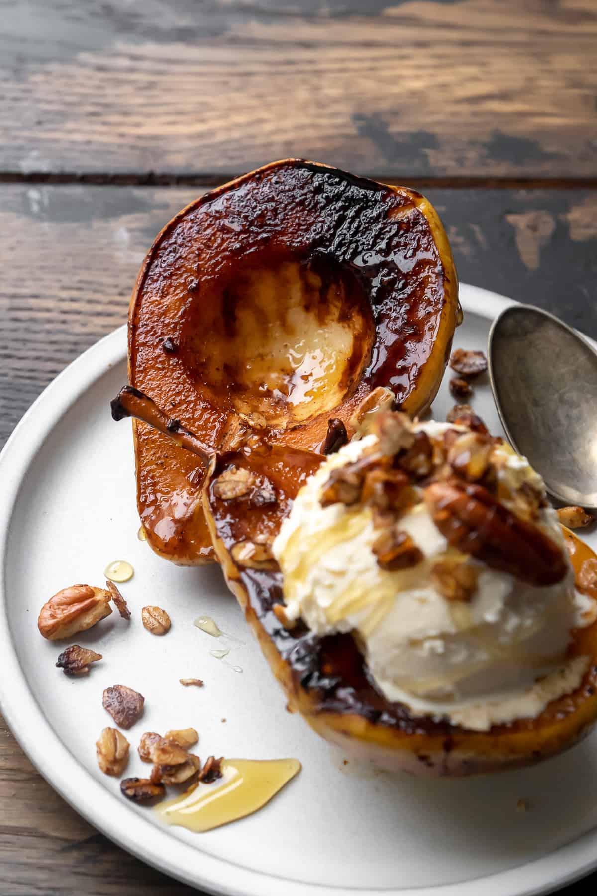 Caramelized pear with scoop of ice cream on top and oats.