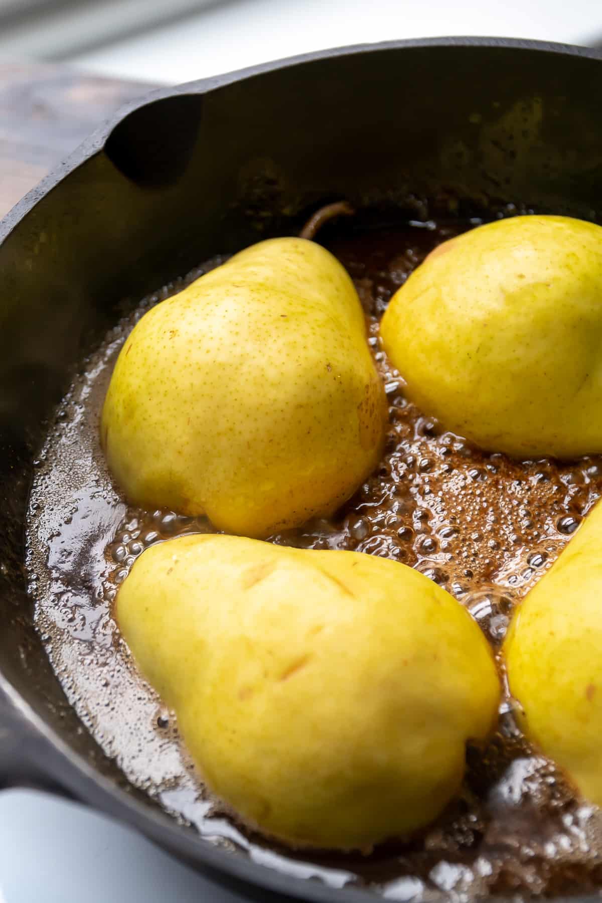 Caramelized pears cooking in a pan.