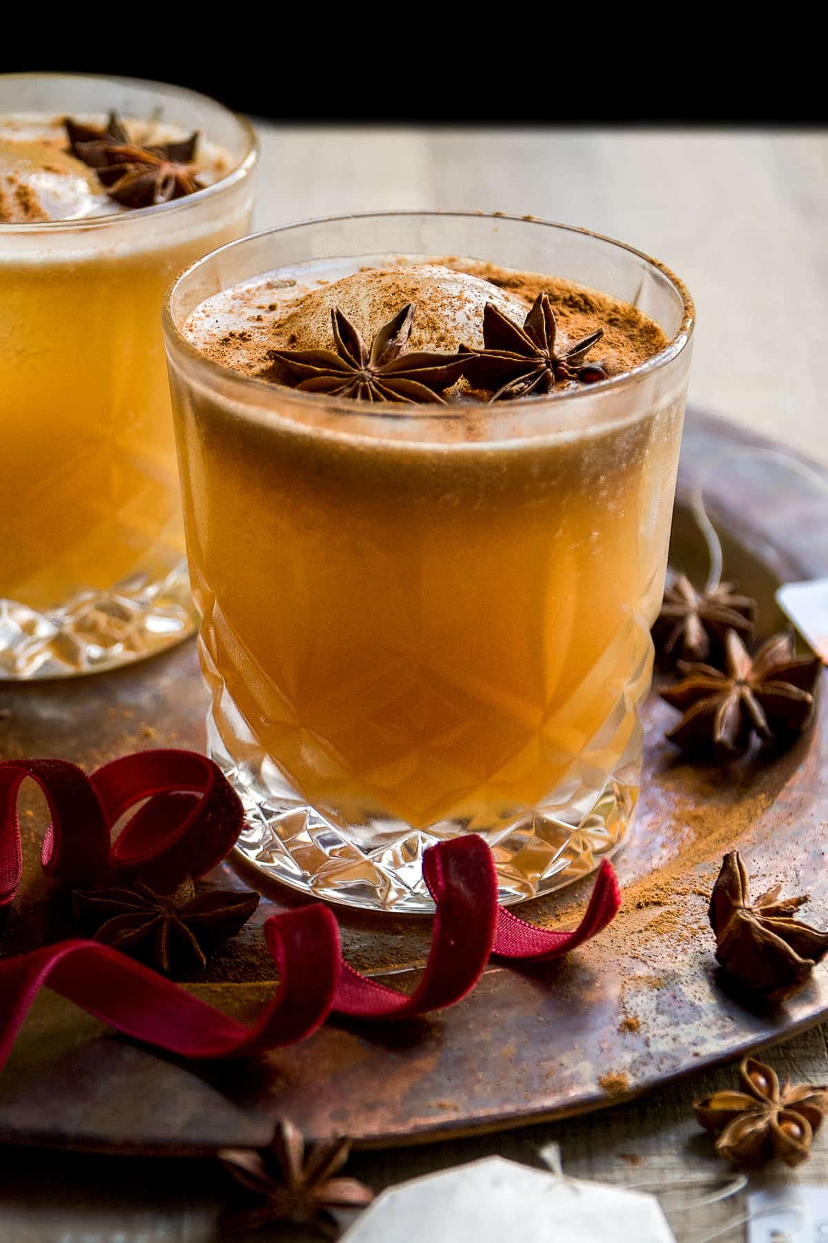 Chai cocktail with bubbles on top and a star anise.