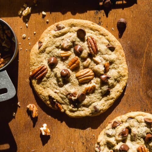 Chocolate chip pecan cookie on brown surface.