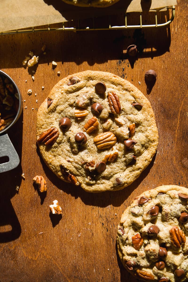 Chocolate chip pecan cookie on brown surface.