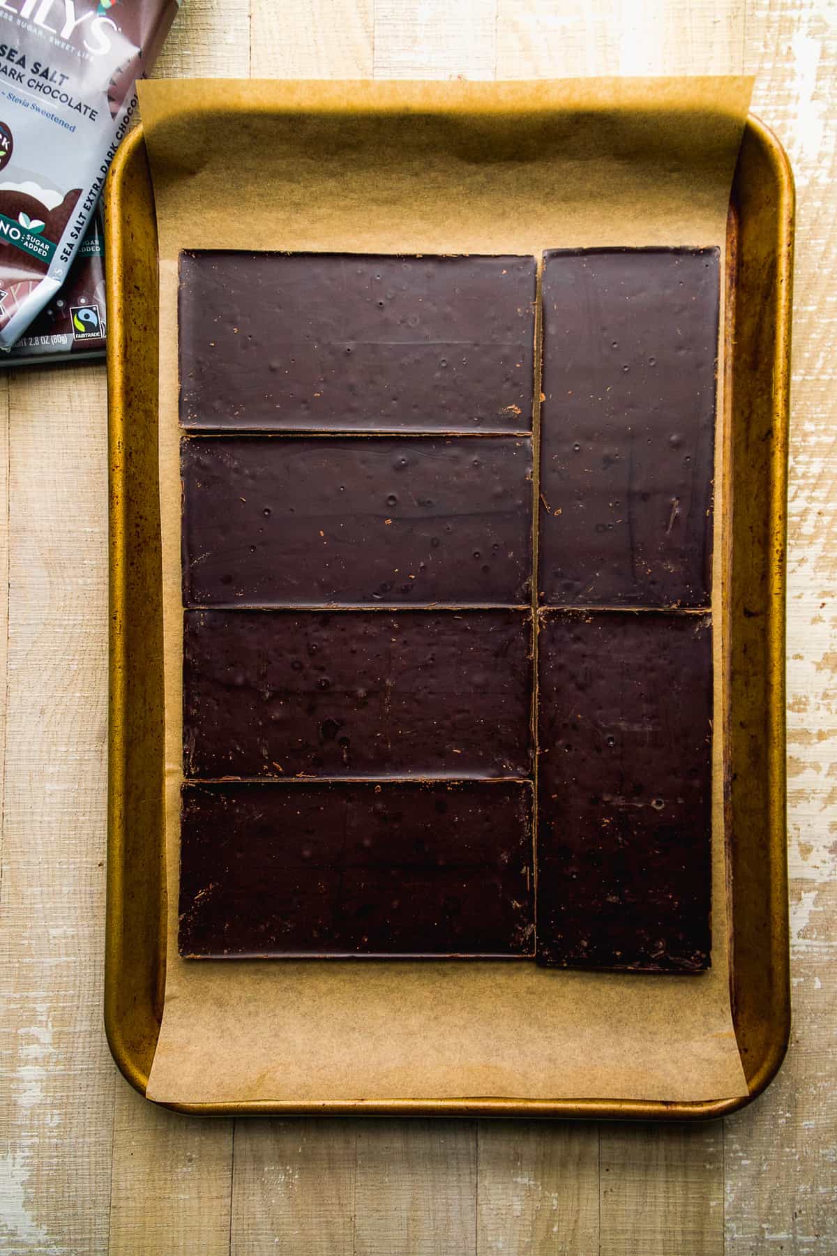 Chocolate bars lined up on a baking sheet.