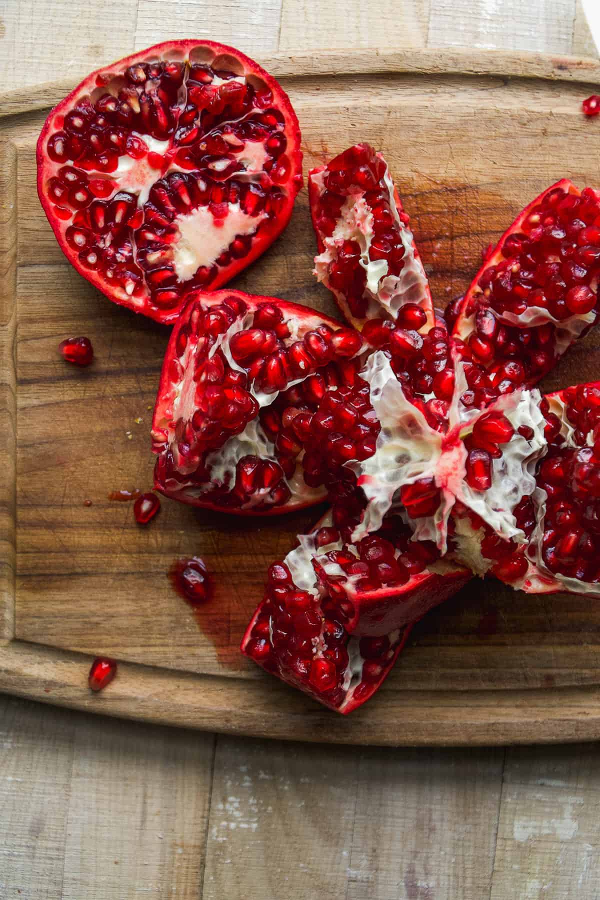 Pomegranate cut up with arils in pods.