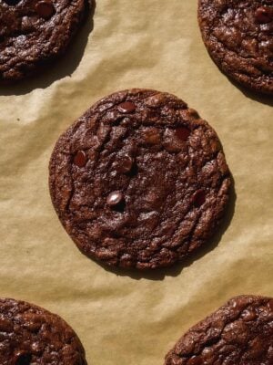 Chocolate brownie crinkle cookies baked on parchment paper.