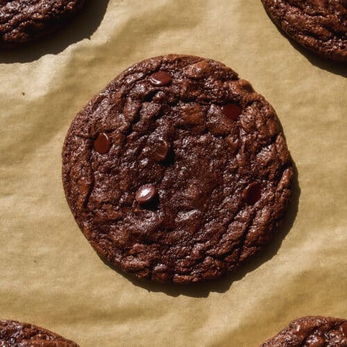 Chocolate brownie crinkle cookies baked on parchment paper.