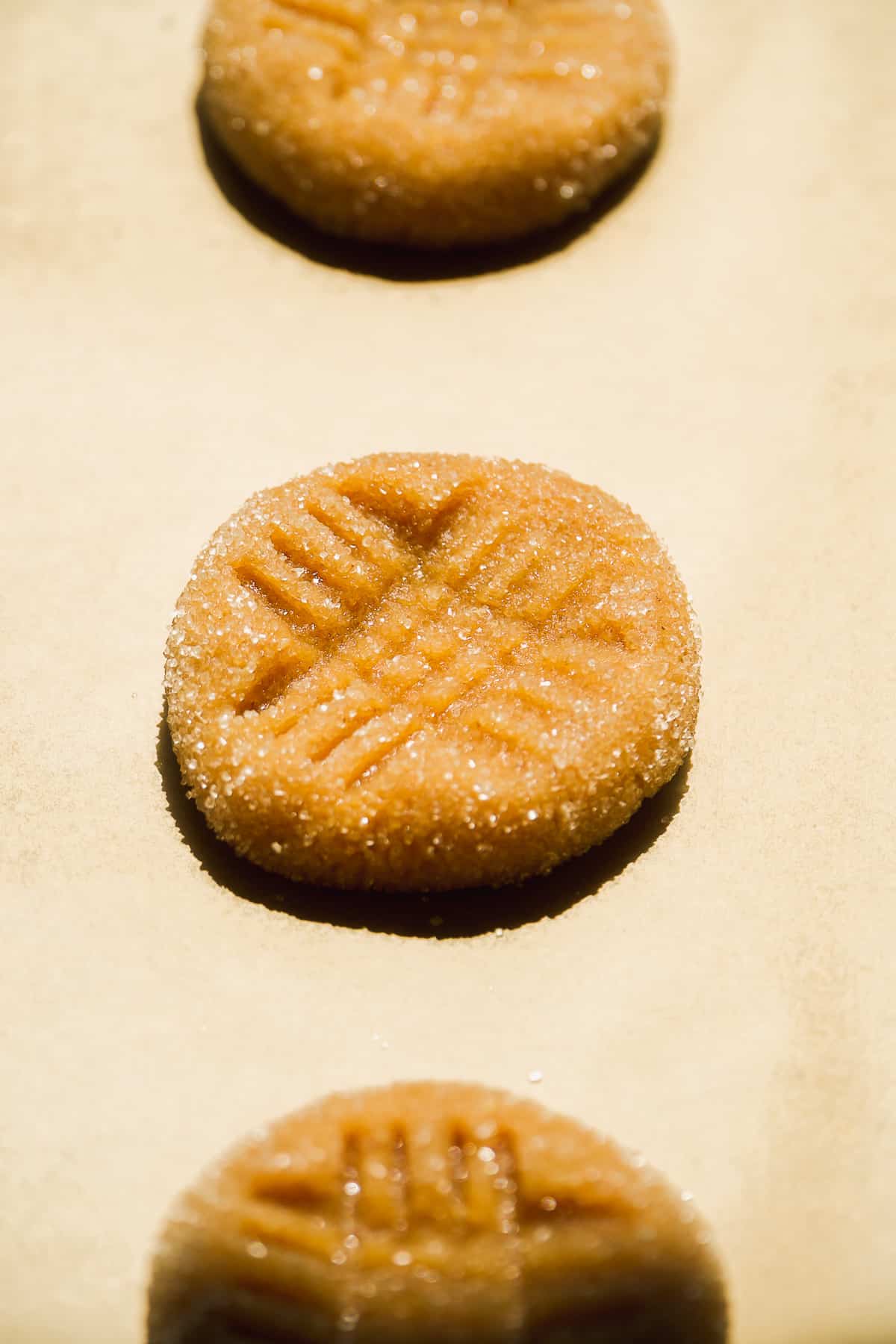 Peanut butter almond flour cookies with hitch hatch marking on top.