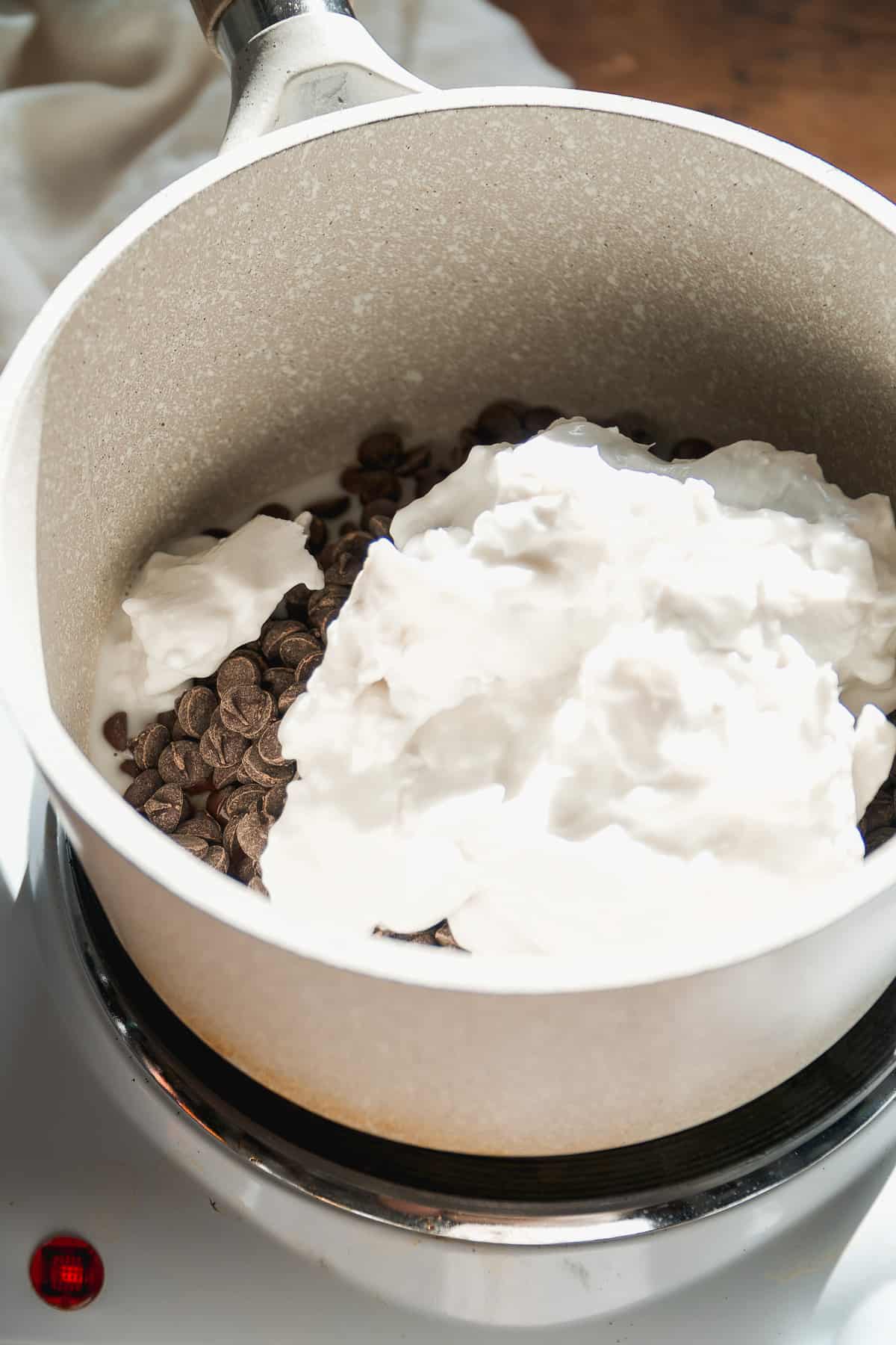 Coconut cream and chocolate melting in a pot.