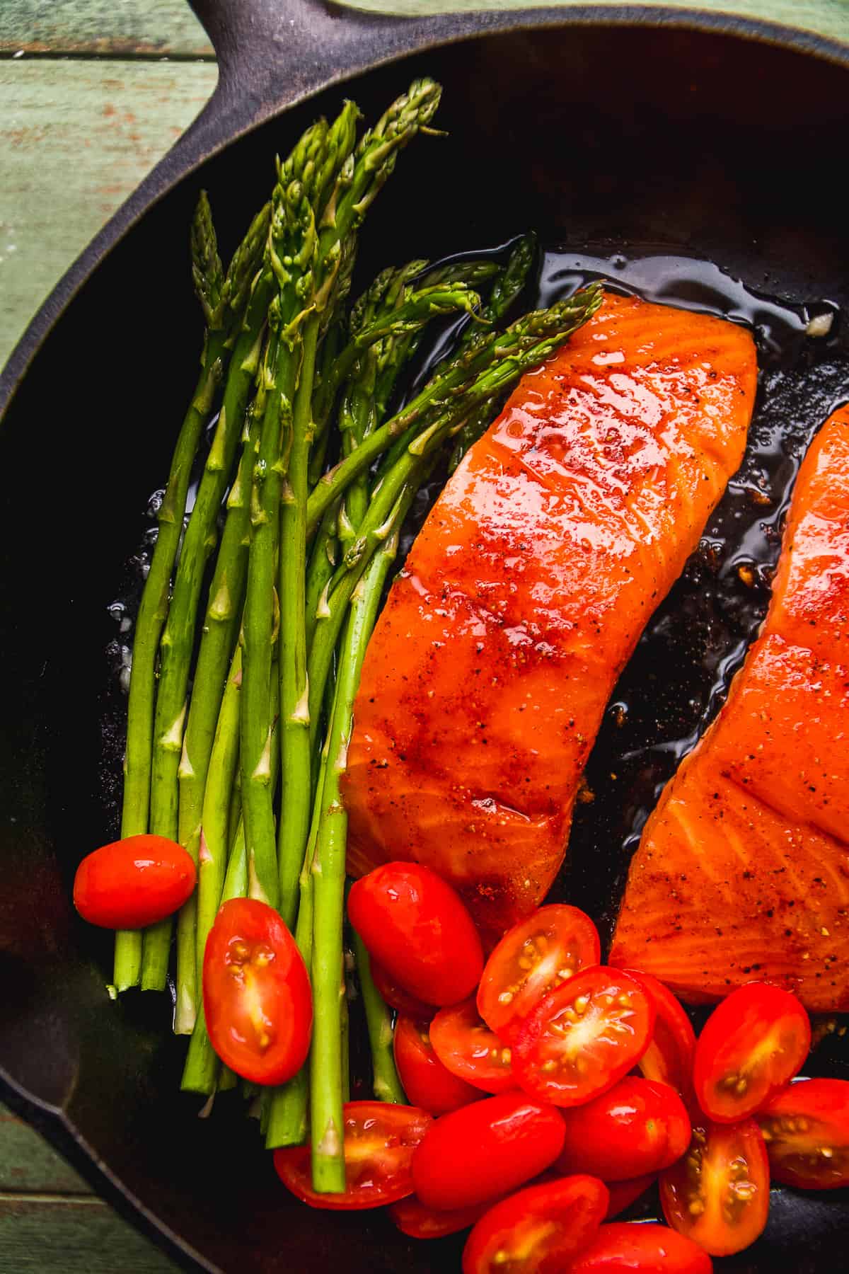 Salmon cooking in the cast iron with veggies.