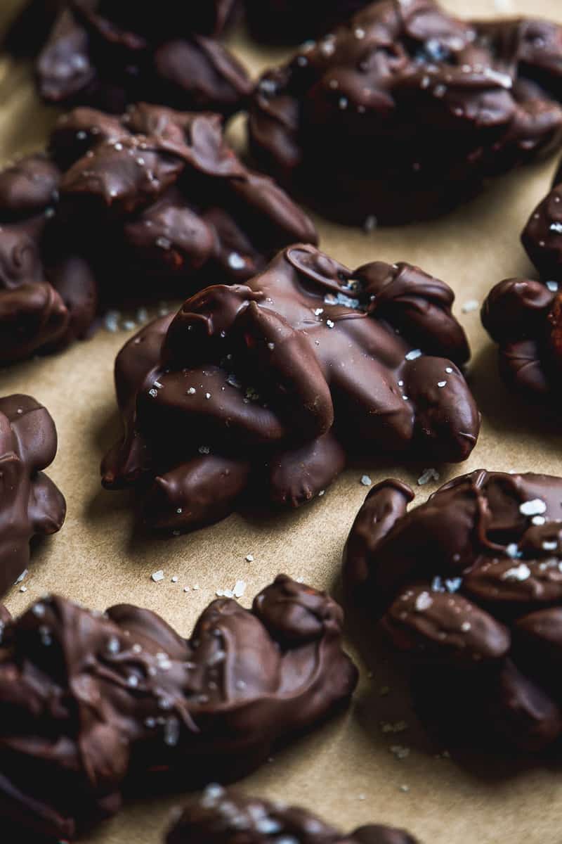 Chocolate almond clusters scattered on a baking sheet.