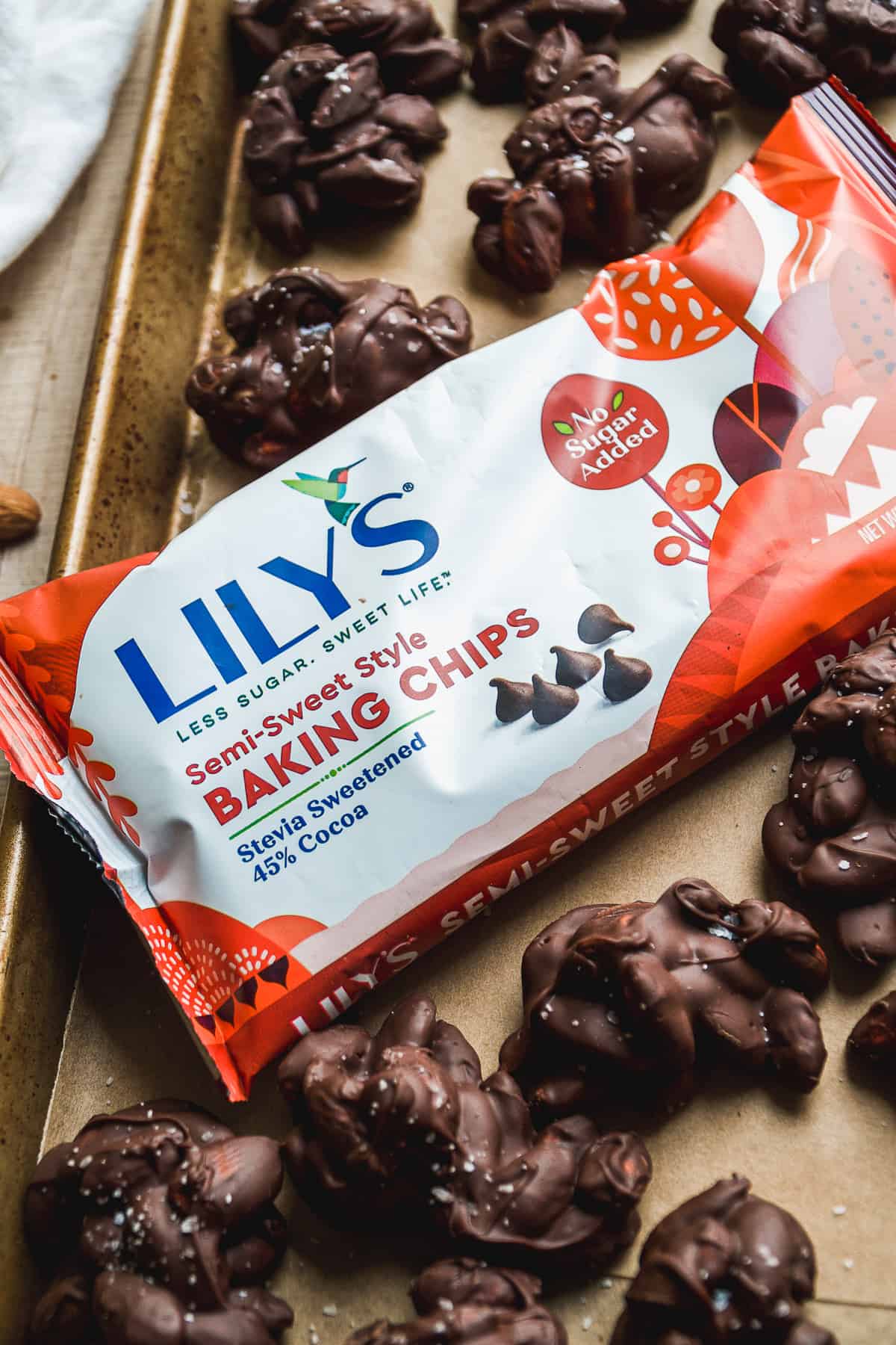 Lily's chocolate chips in a bag on a baking sheet with almond clusters.