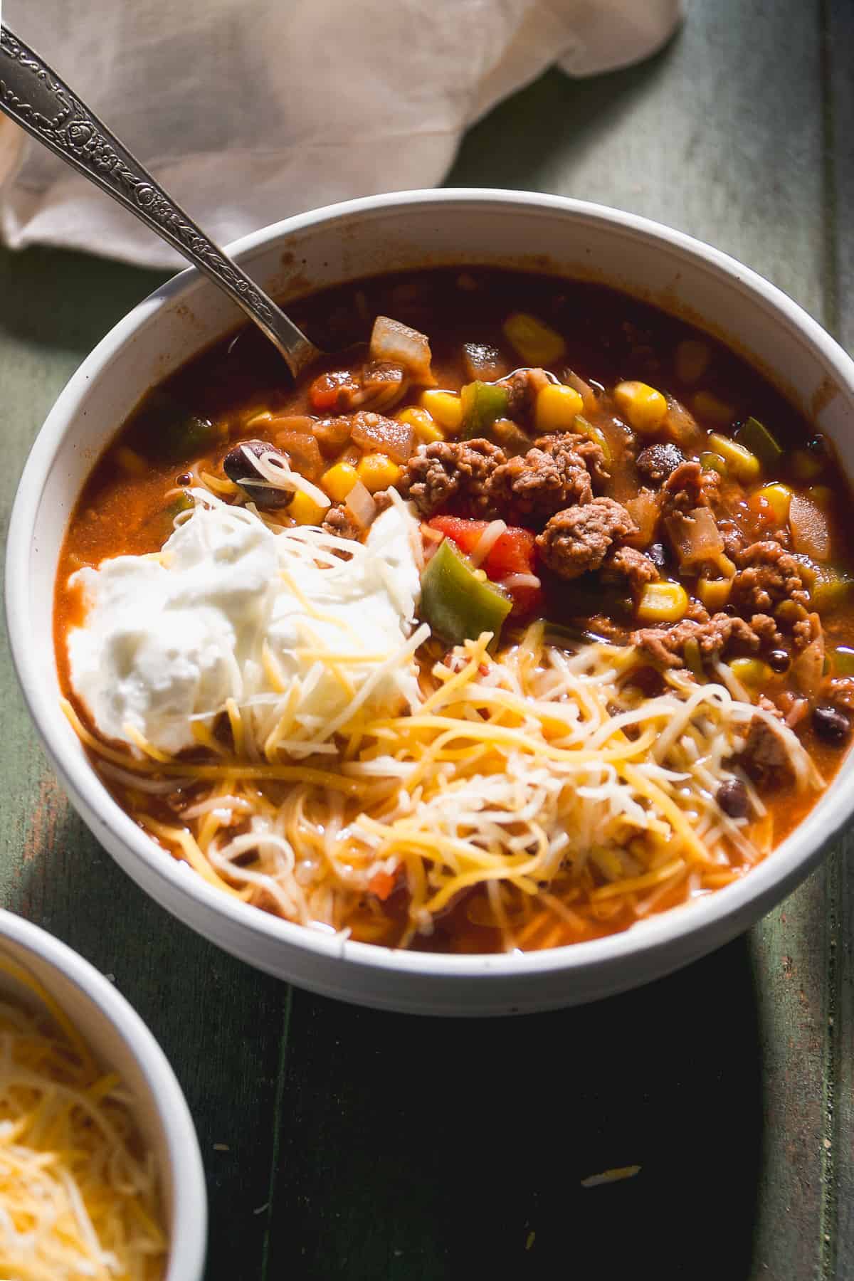 Bowl of sweet chili with cheese and yogurt on top.