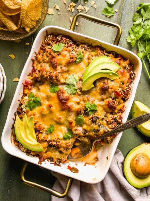 Taco casserole on a green surface with a spoon.