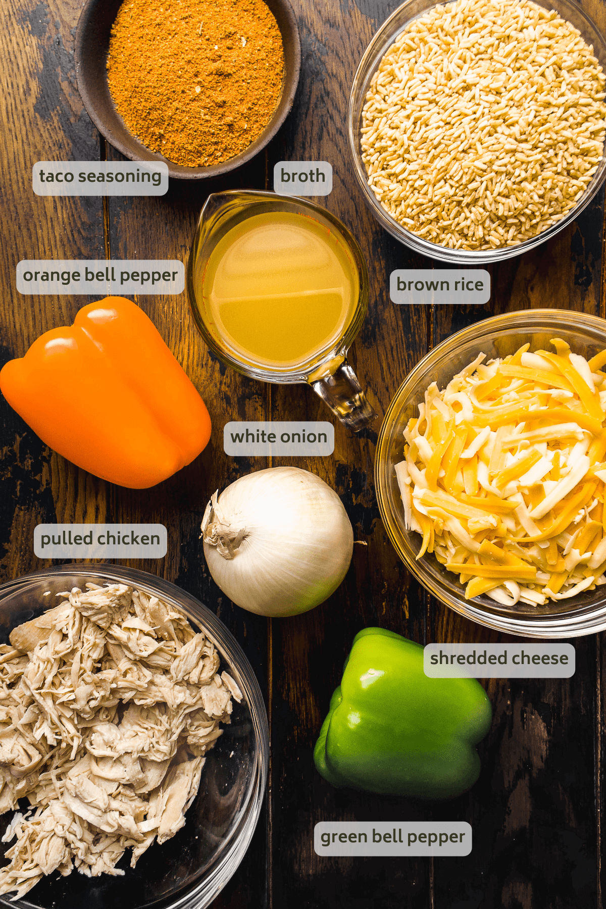 Chicken fajita casserole ingredients on a wooden surface with labels.